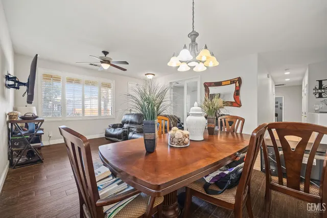a dining room with furniture a chandelier and wooden floor