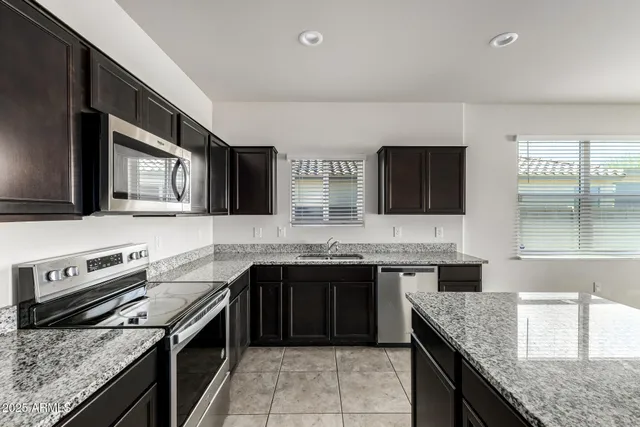a modern kitchen with stainless steel appliances granite countertop a sink and a stove