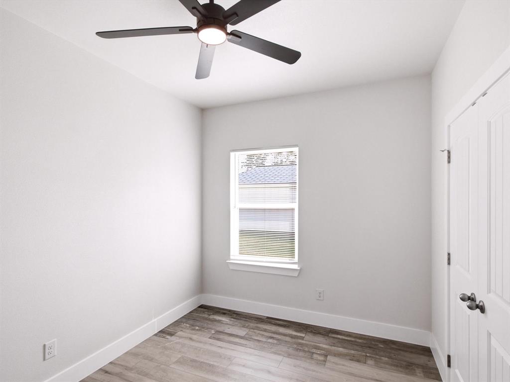 105 Oak Ridge Road Mabank, TX 75156 - Photo 22 of 34 Wood-finish flooring, white walls, ceiling fan with integrated lighting, single window, and white interior door