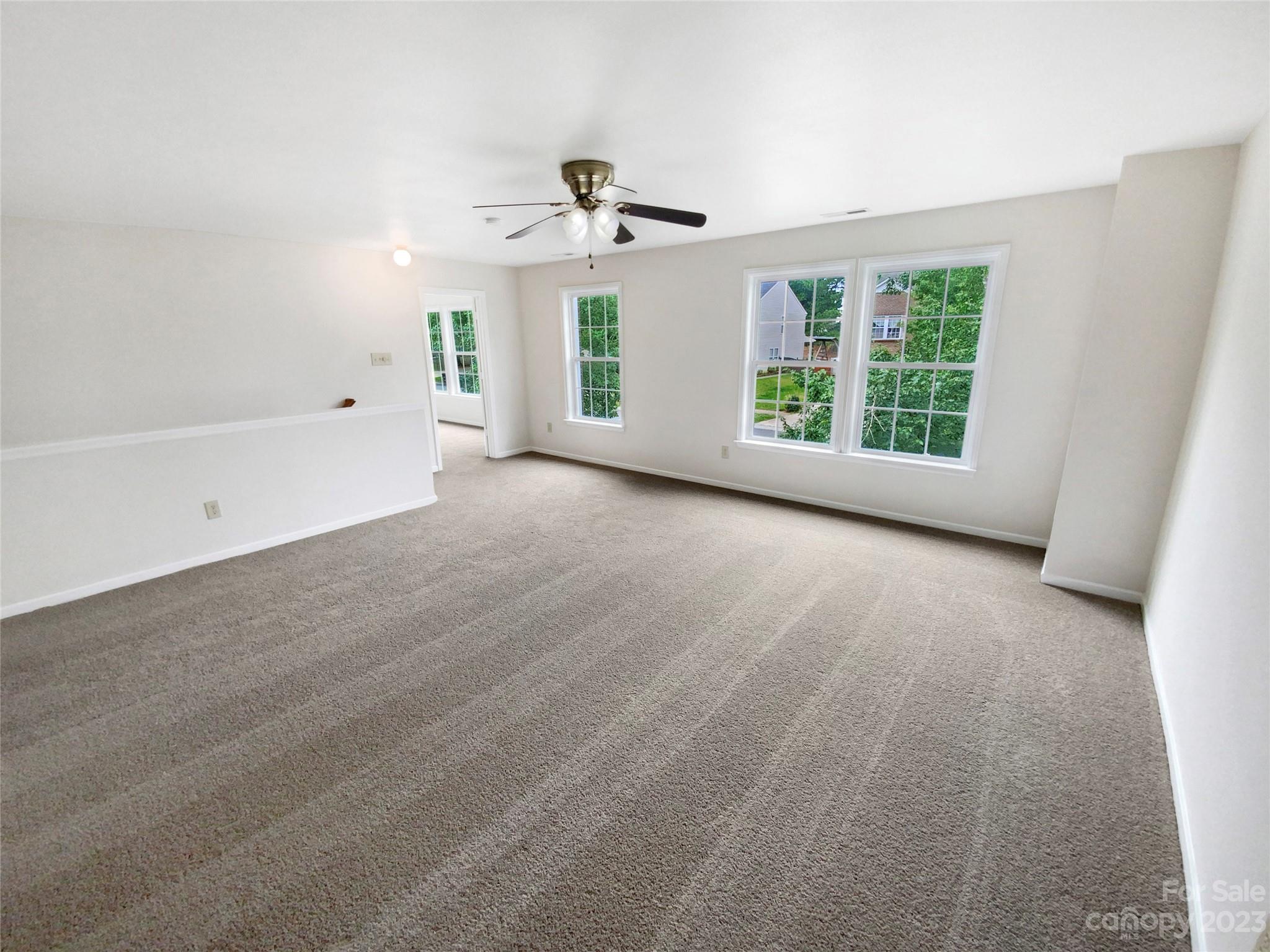 2518 Spring Breeze Way Monroe, NC 28110 - Photo 17 of 22 an empty room with windows and ceiling fan