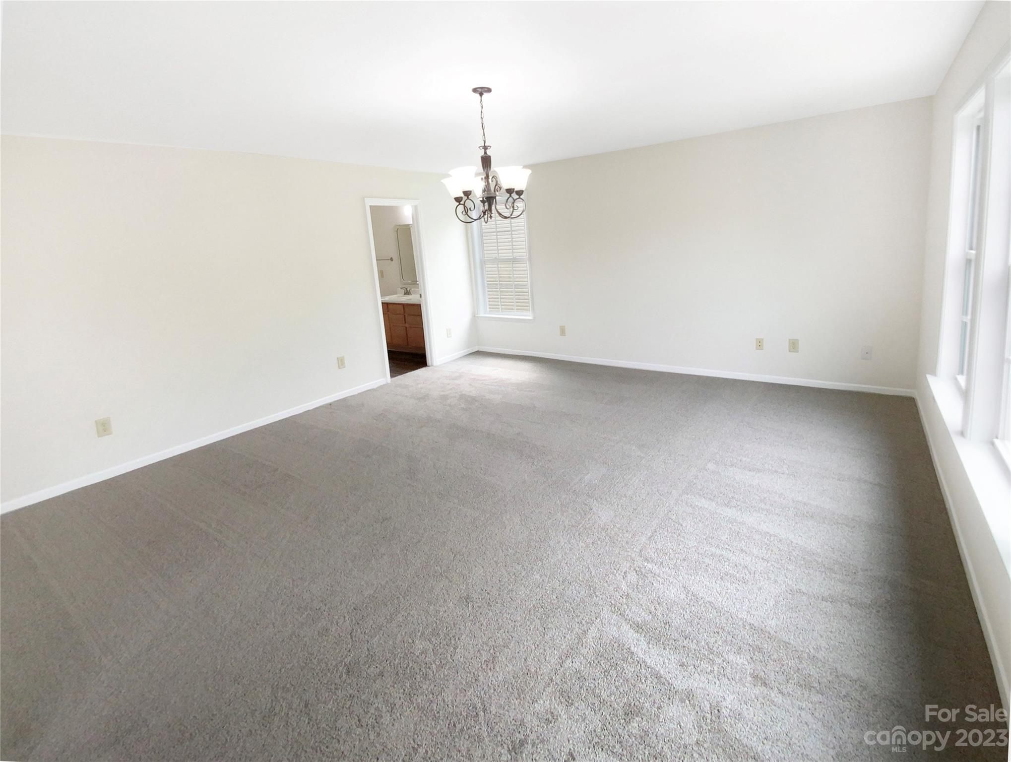 2518 Spring Breeze Way Monroe, NC 28110 - Photo 5 of 22 an empty room with a windows and chandelier fan