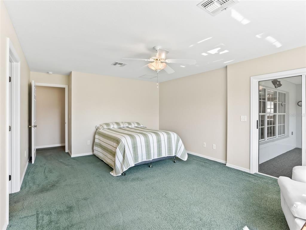 12321 Southeast 176th Loop Summerfield, FL 34491 - Photo 19 of 51 a spacious bedroom with a bed and a couch