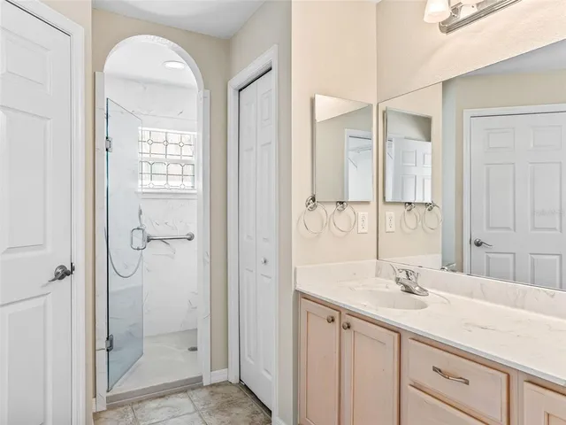 a bathroom with a granite countertop sink a mirror and a shower