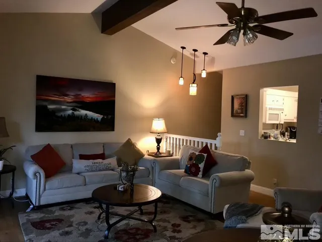 a living room with furniture a lamp and a flat screen tv