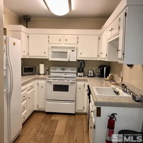 a kitchen with cabinets appliances a sink and a counter top space