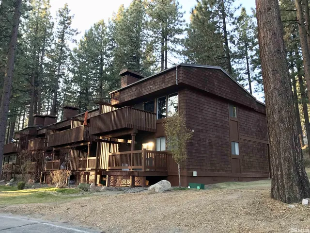 a view of a house with a yard and tree