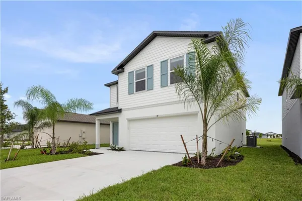a front view of a house with a garden and plants