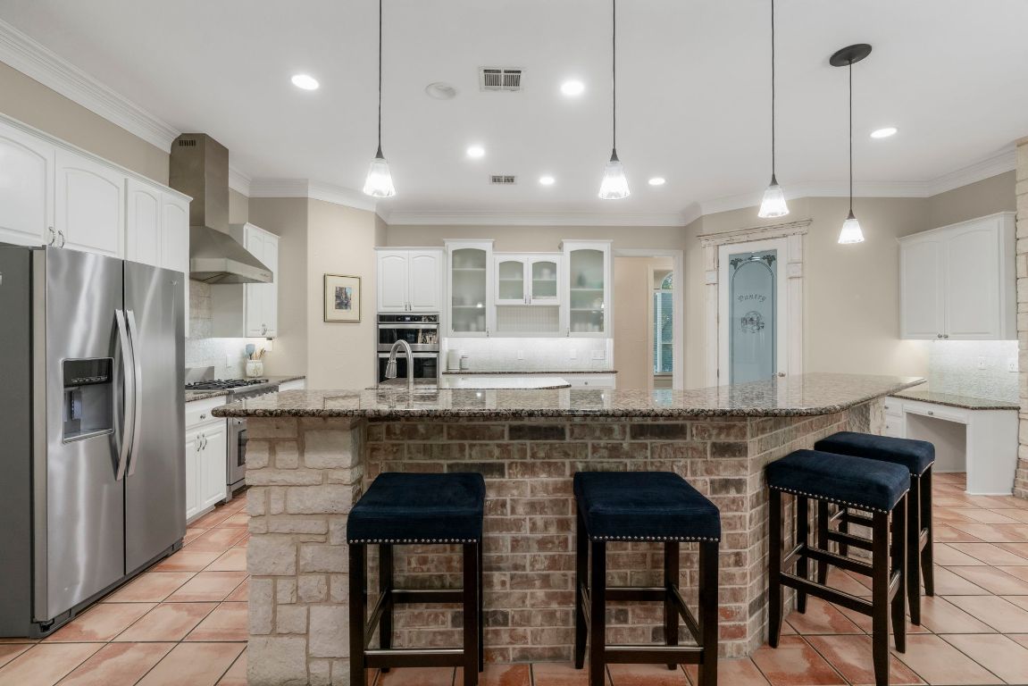 209 Goldridge Drive Georgetown, TX 78633 - Photo 12 of 40 a kitchen with stainless steel appliances granite countertop a stove a refrigerator a kitchen island a sink and a refrigerator