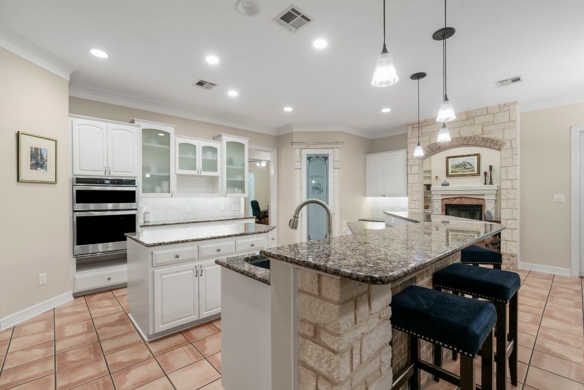 209 Goldridge Drive Georgetown, TX 78633 - Photo 13 of 40 a kitchen with stainless steel appliances kitchen island granite countertop a stove a sink and a microwave