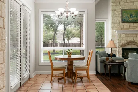 a dining room with furniture a chandelier and wooden floor