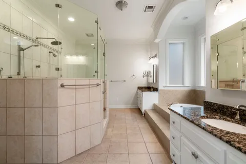 a large bathroom with a granite countertop double vanity sink a mirror and shower
