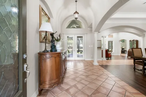 a view of a hallway with a dining table and chairs