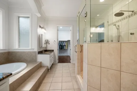 a bathroom with a tub a sink and a large mirror
