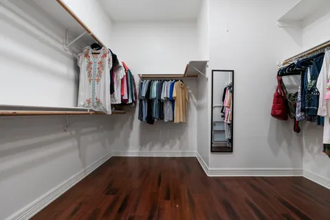 a view of walk in closet with clothes and shoes