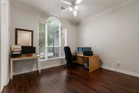 a view of a workspace with wooden floor and a window