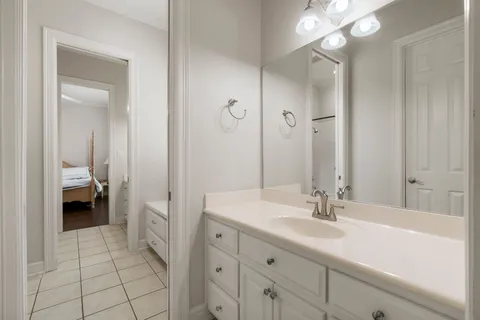 a en suite bathroom with a sink a toilet and a large mirror