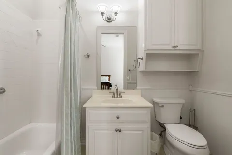 a bathroom with a sink vanity mirror and toilet