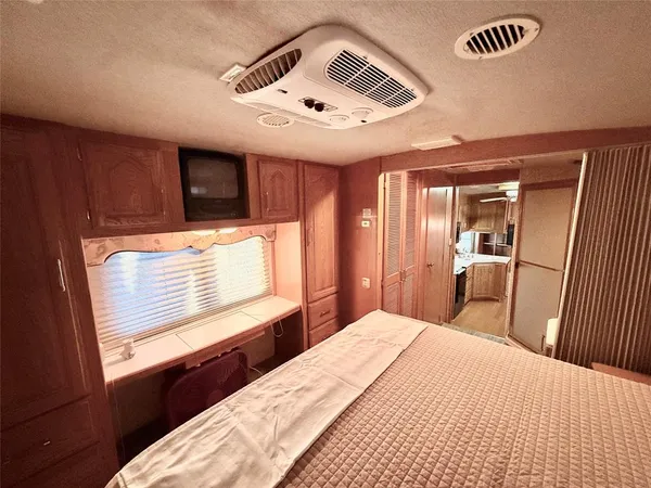a bedroom with a bed and a large mirror with window