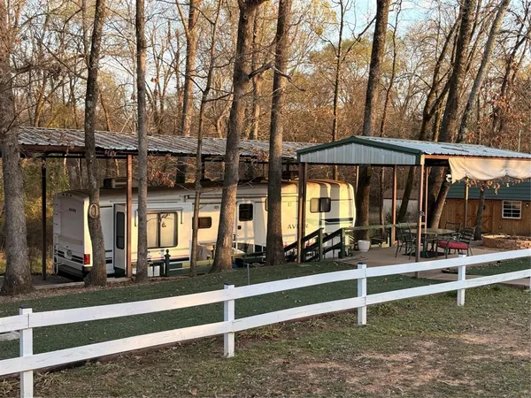 a view of a house with backyard and wooden fence