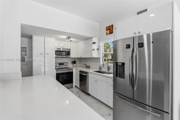 a kitchen with stainless steel appliances a refrigerator sink and stove