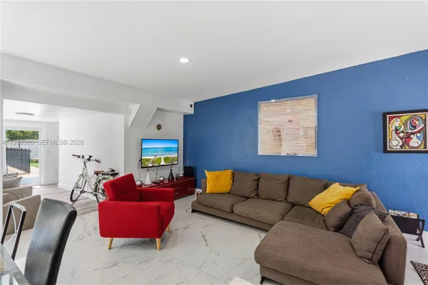 a living room with furniture and kitchen view