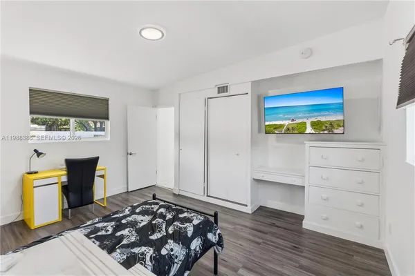 a bedroom with a bed and flat screen tv