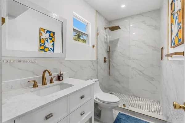 a bathroom with a sink a toilet and shower