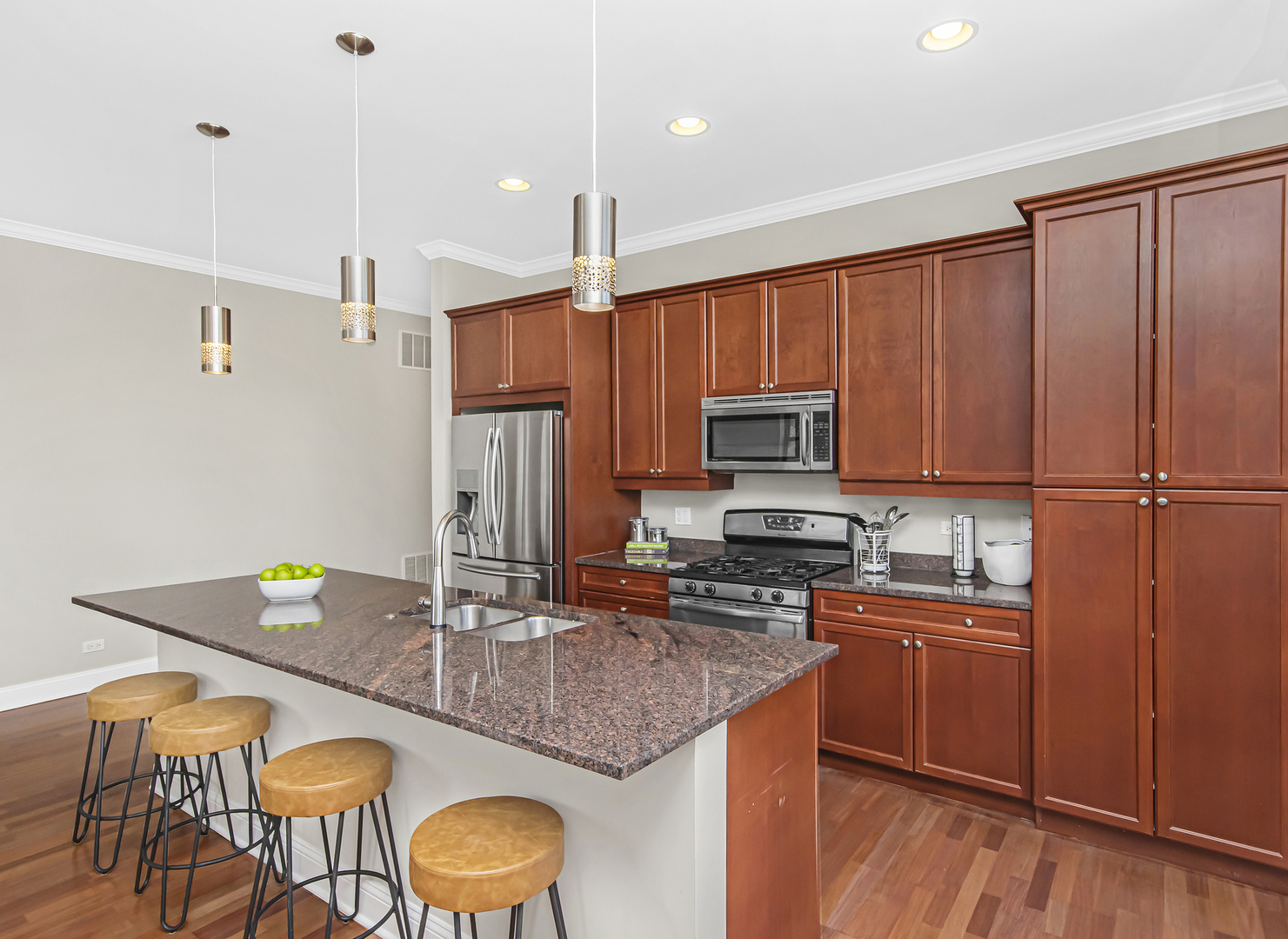 1908 West Irving Park Road, Unit 303 Chicago, IL 60613 - Photo 8 of 22 a kitchen with kitchen island granite countertop a sink a counter space appliances and cabinets