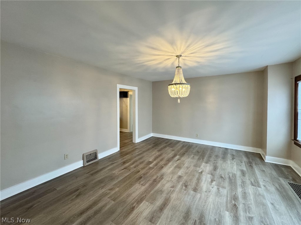 507 Canton Road Wintersville, OH 43953 - Photo 11 of 45 Unfurnished room featuring a chandelier and dark wood-type flooring