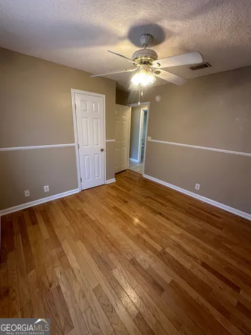 a view of an empty room with a chandelier fan