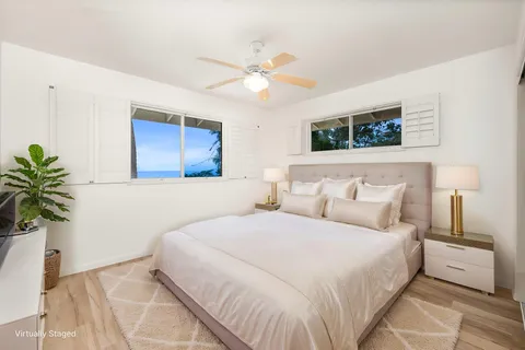 a bedroom with a large bed and a potted plant