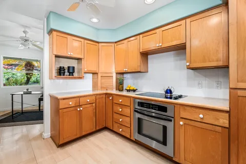 a kitchen with stainless steel appliances granite countertop white cabinets a sink and a refrigerator