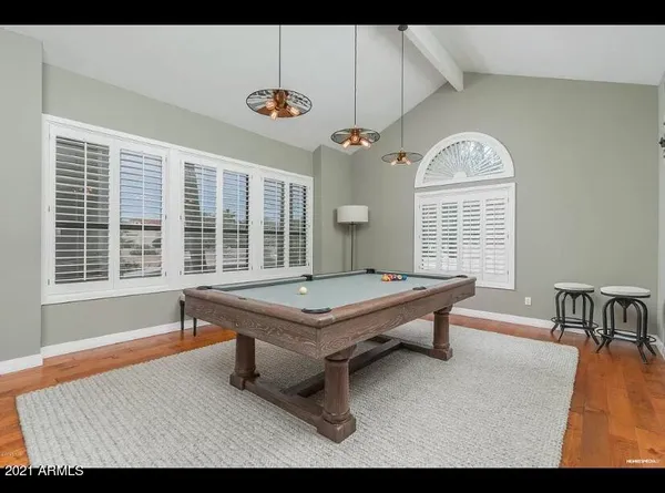 a room with pool table and windows