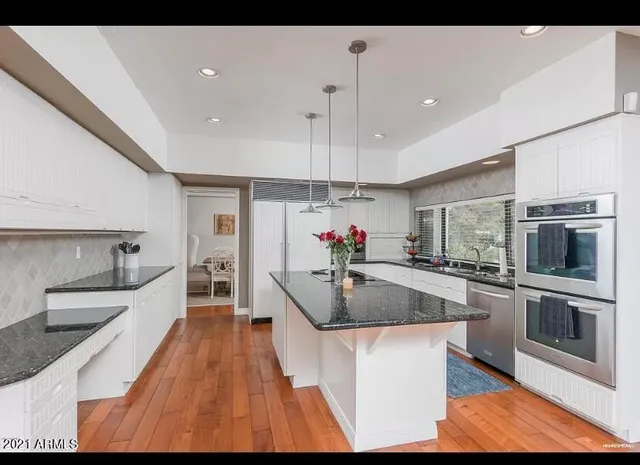 a kitchen with stainless steel appliances granite countertop a sink stove and refrigerator