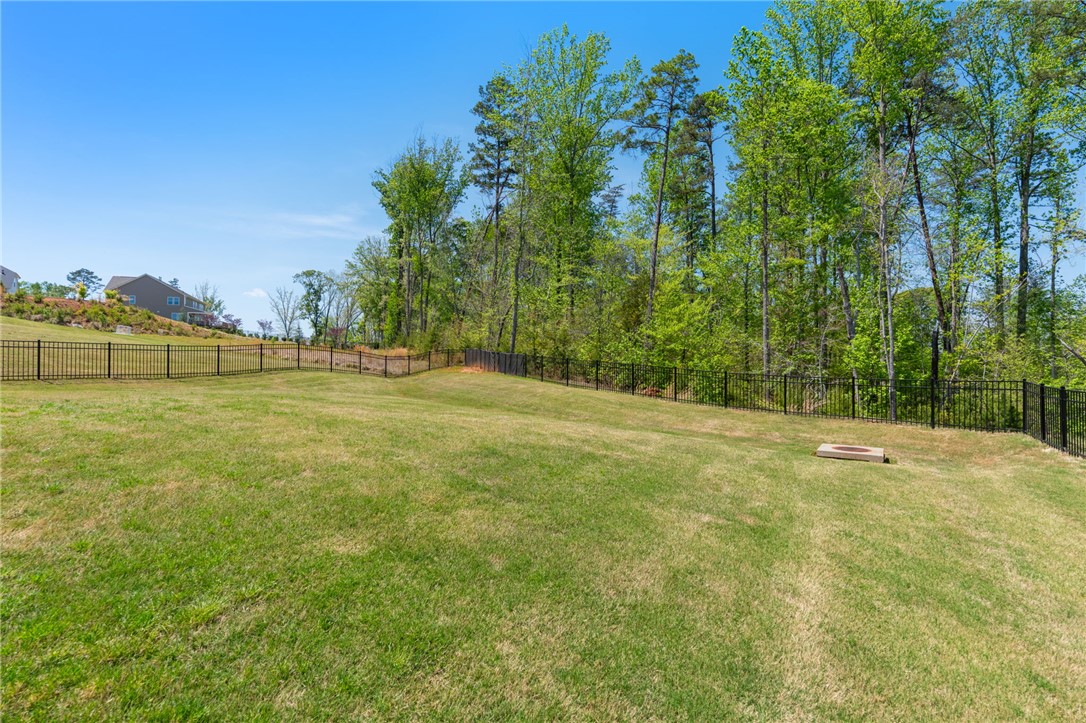 210 Maverick Trail Central, SC 29630 - Photo 32 of 41 Expansive green lawn, fenced for privacy, offers a serene backdrop against mature trees.