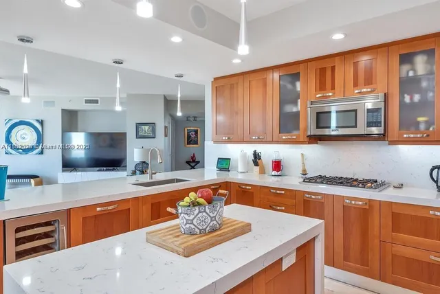 a large kitchen with stainless steel appliances granite countertop a sink wooden cabinets and a granite counter top