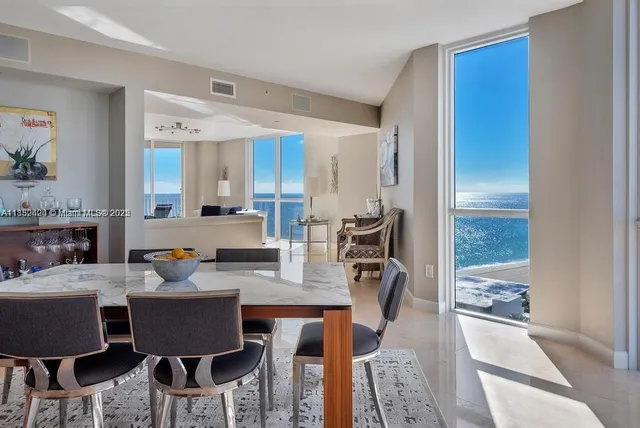 a view of a dining room with furniture a chandelier and wooden floor