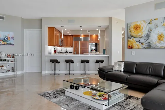a living room with furniture and a view of kitchen