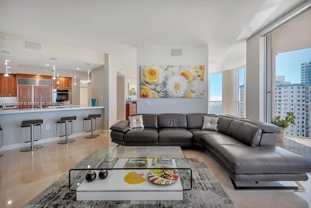 a living room with furniture a wooden floor and a large mirror