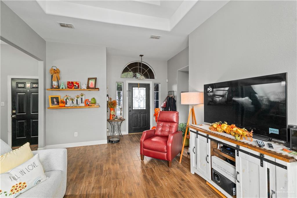 718 Hummingbird Avenue Pharr, TX 78577 - Photo 3 of 13 a living room with furniture a flat screen tv and floor to ceiling window