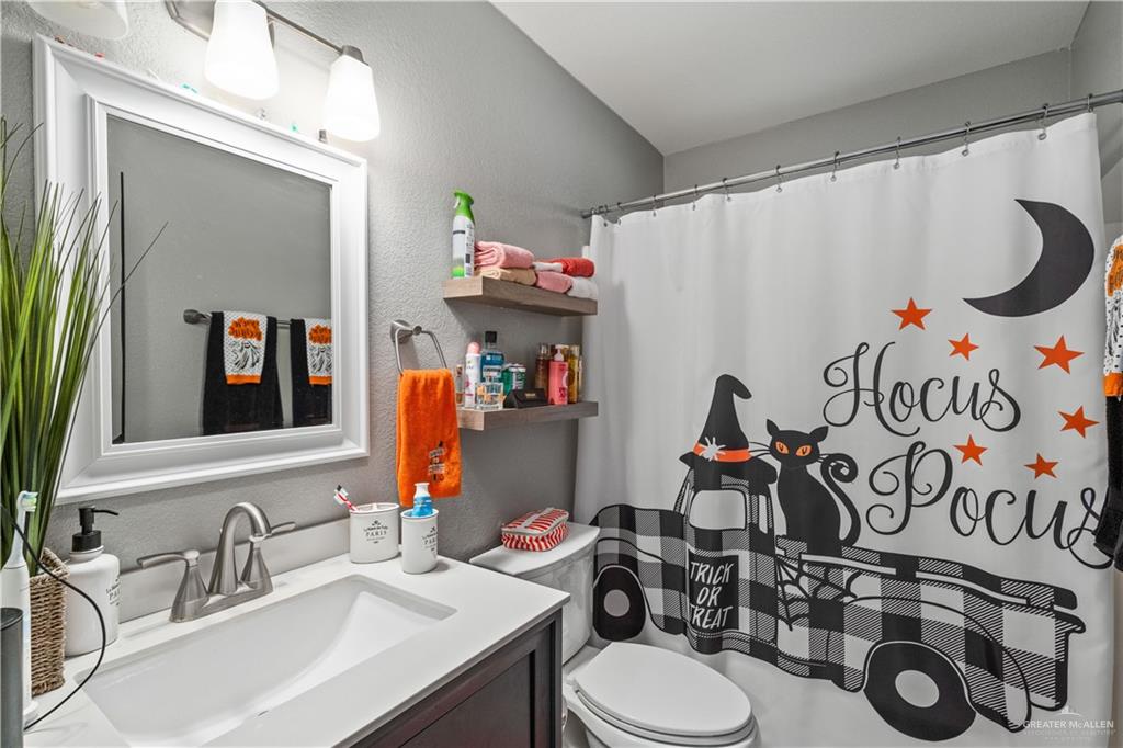 718 Hummingbird Avenue Pharr, TX 78577 - Photo 9 of 13 a bathroom with a sink mirror vanity and toilet