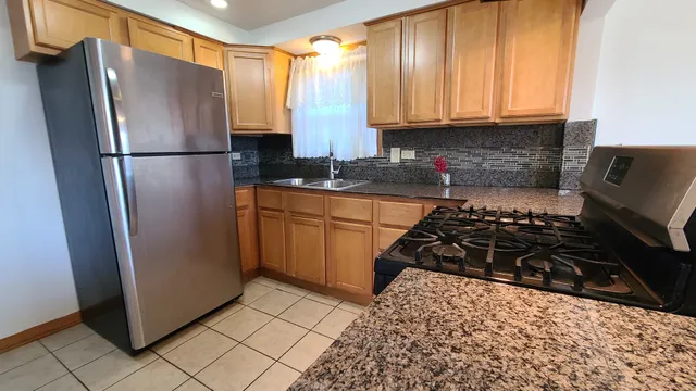 a kitchen with stainless steel appliances granite countertop a refrigerator and a stove