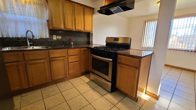 a kitchen with stainless steel appliances granite countertop a stove a sink and a microwave