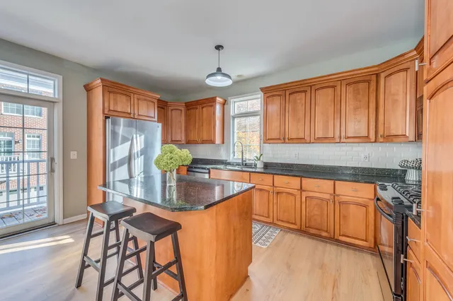 a kitchen with stainless steel appliances granite countertop sink stove top oven and cabinets