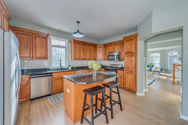 a kitchen with stainless steel appliances granite countertop sink stove top oven and cabinets