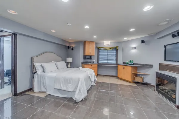 a large bedroom with a large bed and a view of kitchen