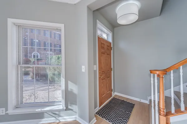 a view of a room that has a large window and wooden floor