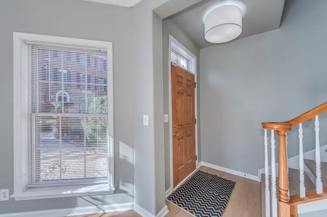 a view of a room that has a large window and wooden floor