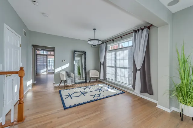 a living room with furniture large window and wooden floor