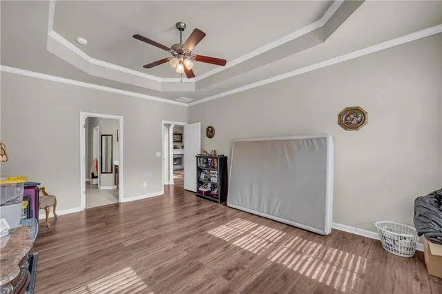 a view of a livingroom with wooden floor and a ceiling fan